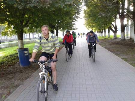 Группа велосипедистов проезжает мимо стадиона в Светлом