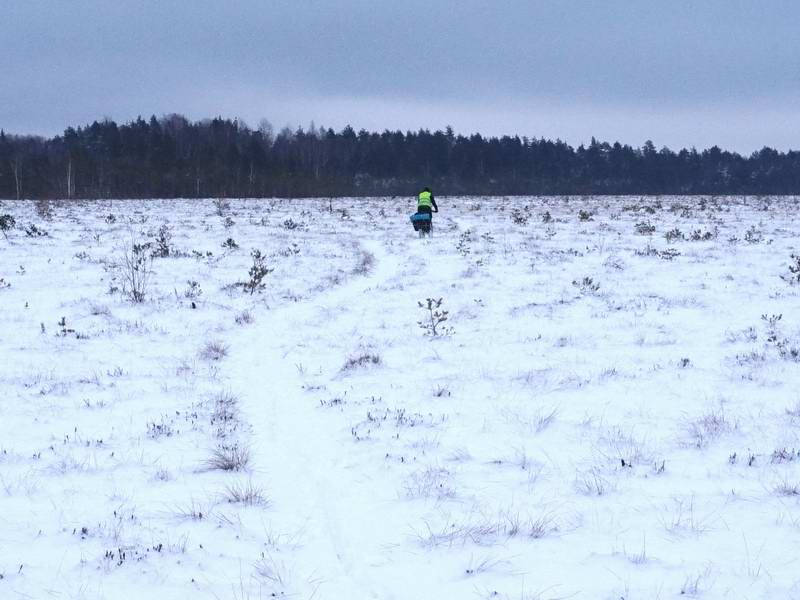 Сергей Мезенов едет по деревянному настилу, спрятанному под снегом