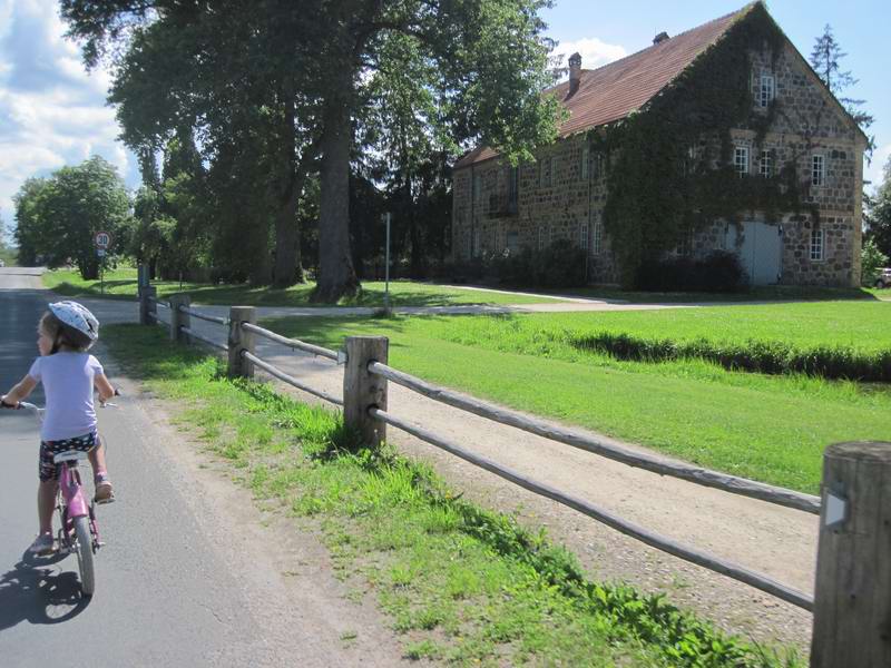 Илиана едет мимо каменного дома