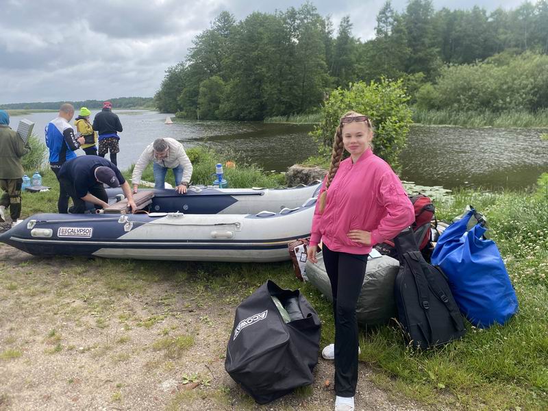 Елена Лобастова на фоне моторной лодки сопровождения водной группы
