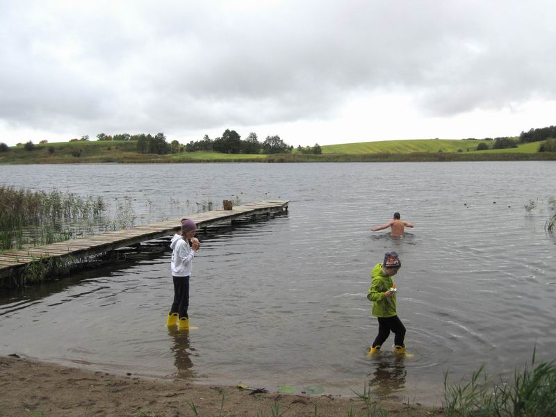 Дети тестируют сапоги на фоне купающегося Евгения Клочко